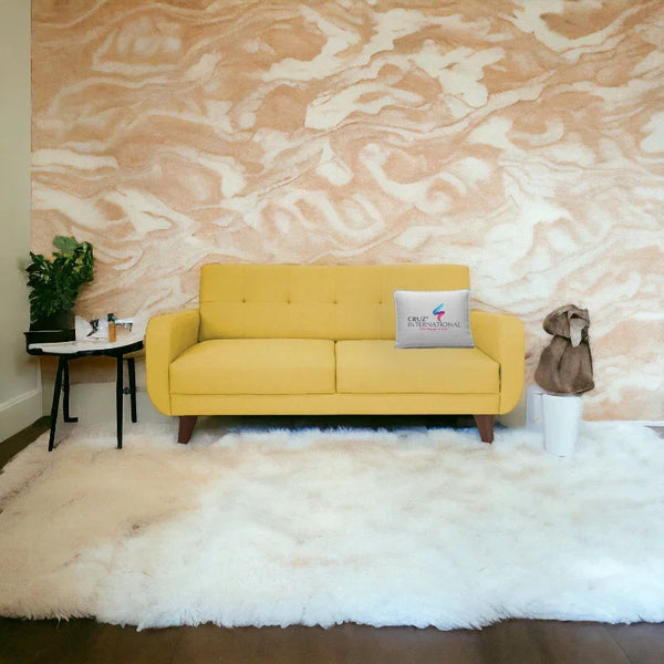 Yellow sofa on white rug with CRUZ INTERNATIONAL pillow, modern living room furniture setup.