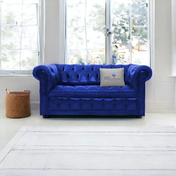 Blue tufted sofa with CRUZ INTERNATIONAL pillow in a bright modern living room