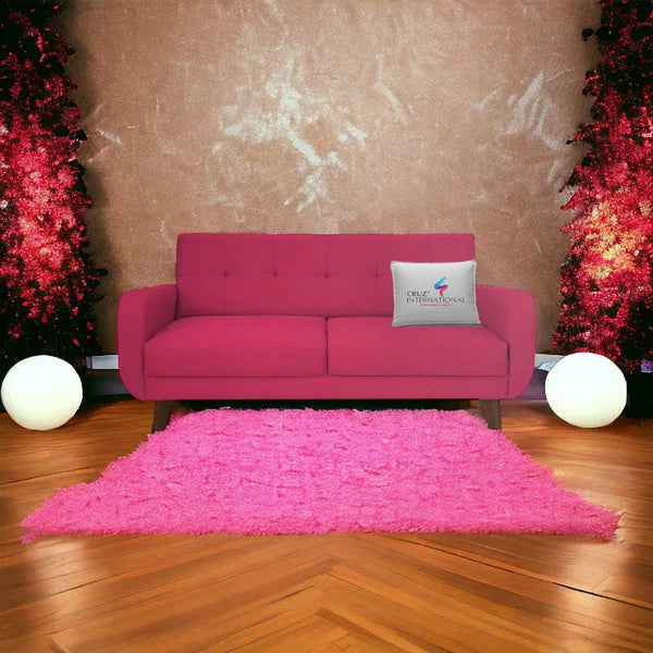 Modern pink sofa with button tufting, pink rug, and CRUZ INTERNATIONAL pillow in stylish living room