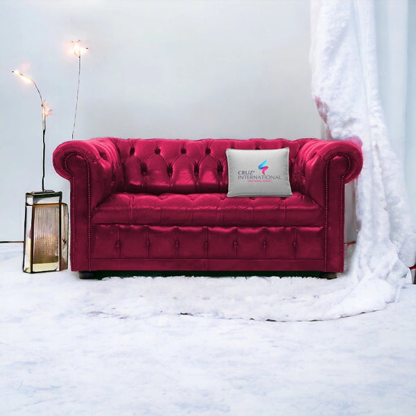 Pink tufted sofa with rolled arms, CRUZ INTERNATIONAL pillow, modern floor lamp, white decor