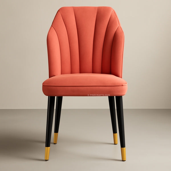 Orange upholstered chair with black legs and gold feet on a beige background