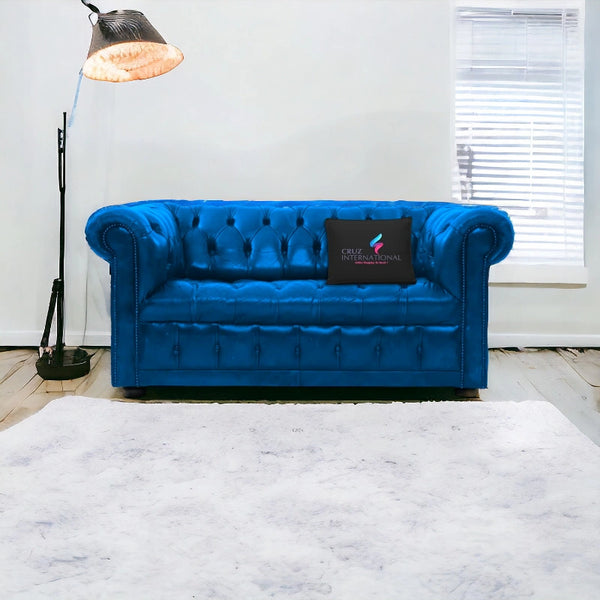 Blue tufted sofa in modern living room with floor lamp, CRUZ INTERNATIONAL pillow, white rug