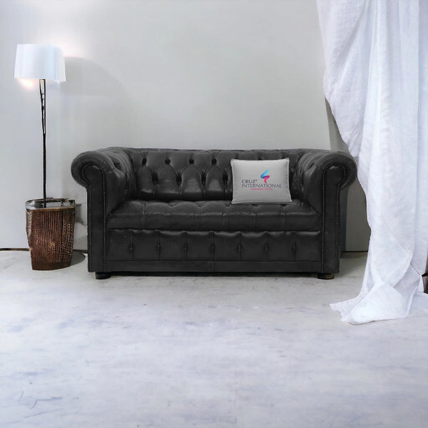 Grey tufted leather sofa with Cruz International cushion, floor lamp and curtain, modern living room furniture.