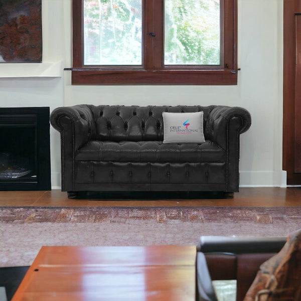 Gray tufted leather sofa with CRUZ INTERNATIONAL pillow in modern living room setting