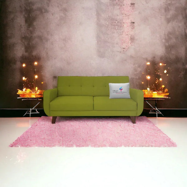 Modern green sofa with CRUZ INTERNATIONAL cushion, pink rug, and decorative lighting in living room