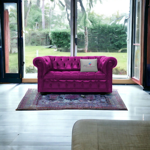 Pink tufted sofa on patterned rug by window, CRUZ INTERNATIONAL furniture showroom