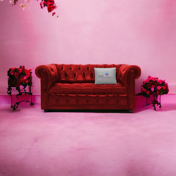 Red leather Chesterfield sofa with CRUZ INTERNATIONAL pillow, pink wall, floral decor, luxury furniture