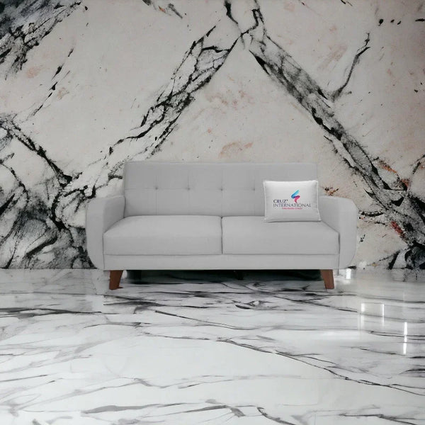 Modern light gray sofa on marble floor with CRUZ INTERNATIONAL pillow, designer furniture store