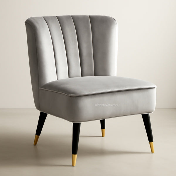 Gray velvet chair with black legs and gold feet on a beige background