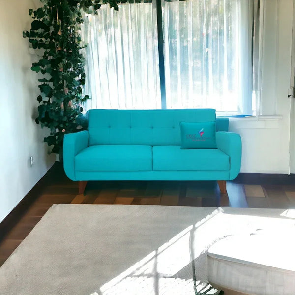Sky blue modern sofa in bright living room with wood floor, potted plant, and sheer curtains