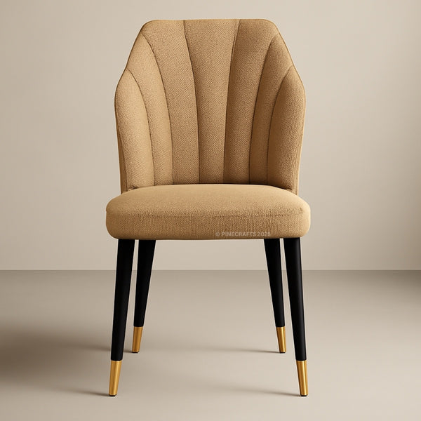 Beige upholstered chair with black legs and gold tips on a beige background