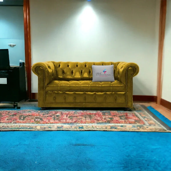 Yellow tufted velvet sofa with rolled arms and CRUZ INTERNATIONAL pillow in a modern living room